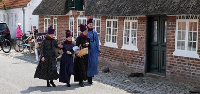 Mädchen laufen in der traditionellen Frauentracht durch Sönderho