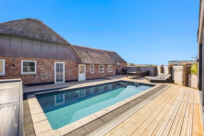 Ferienhaus mit Außenpool in Dänemark mit Terrasse und Sonnenliegen an der Nordseeküste