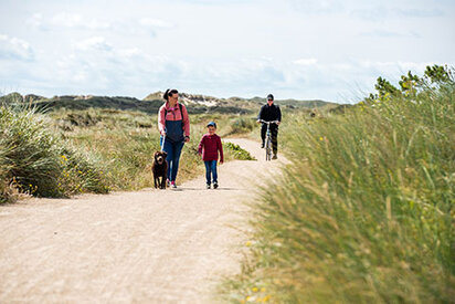 Gåtur gennem klitterne med hund i snor ved Hvide Sande