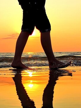 Stopper i vandkanten ved solnedgang på Vejers Strand. 